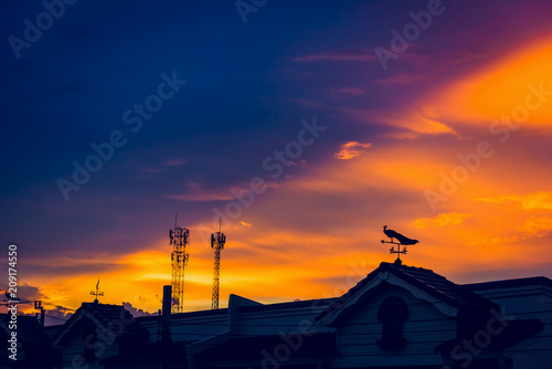 weather vane at sunrise with bright colors in clouds