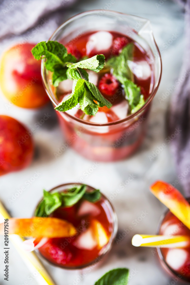 Light summer refreshing drink with fruits and berries - sangria. In glasses on a gray table. Top view, flat lay Light summer refreshing drink with fruits and berries - sangria. In glasses on a gray table. Top view, flat lay