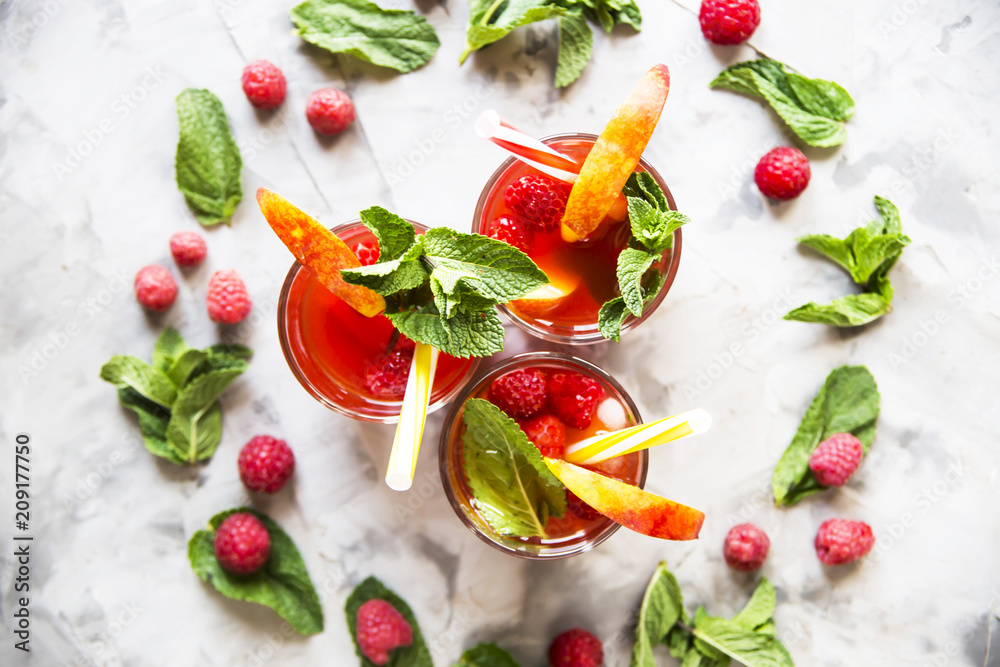 Light summer refreshing drink with fruits and berries - sangria. In glasses on a gray table Top view, flat lay Light summer refreshing drink with fruits and berries - sangria. In glasses on a gray table Top view, flat lay