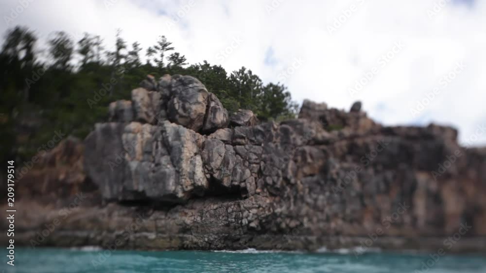 A shot of brown rock formations. Trees are seen growing in the background. A shot of brown rock formations. Trees are seen growing in the background.