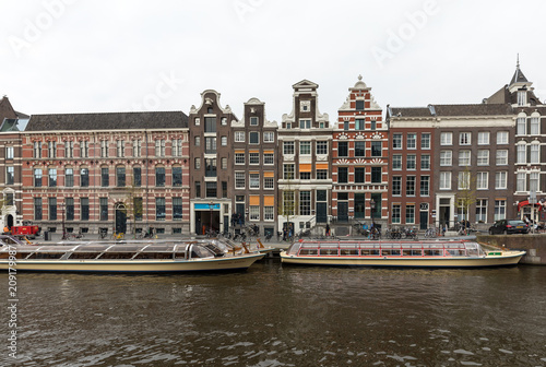 View on Rokin Canal, Oude Turfmarkt street and Tourboats ready for canal cruises in Amsterdam, Holland, Netherlands. photo