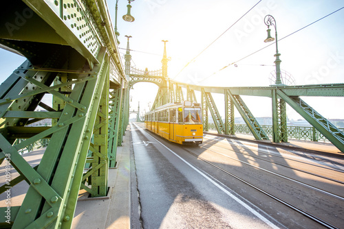 View on the famous Liberty bridge with old yellow tram during the morning light in Budapest, Hungary