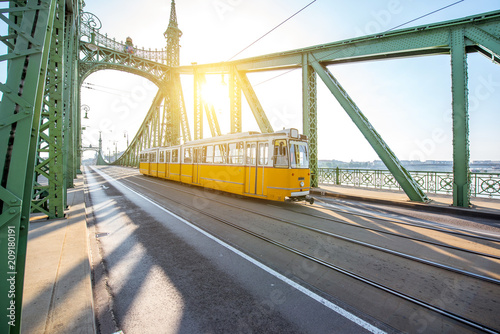 View on the famous Liberty bridge with old yellow tram during the morning light in Budapest, Hungary