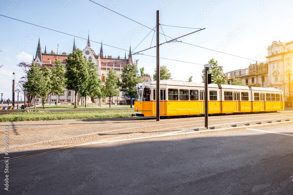 Yellow tram with Parliament building on the background in Budapest city, Hungary