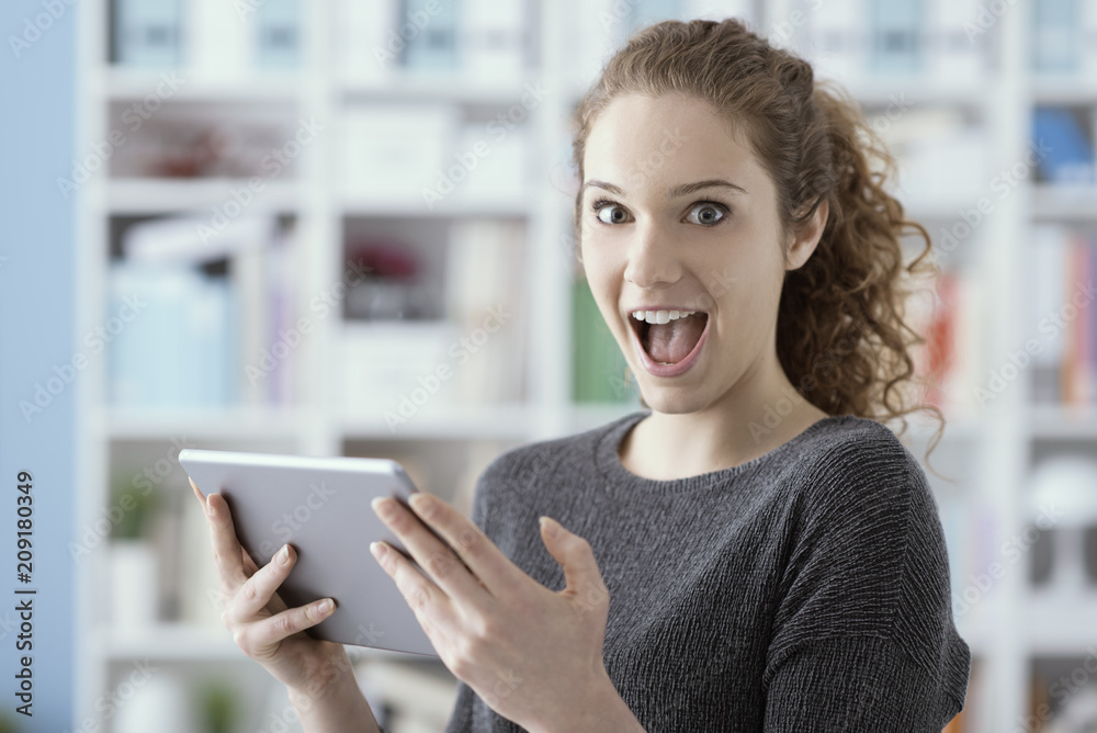 Surprised cheerful girl connecting with her tablet Surprised cheerful girl connecting with her tablet