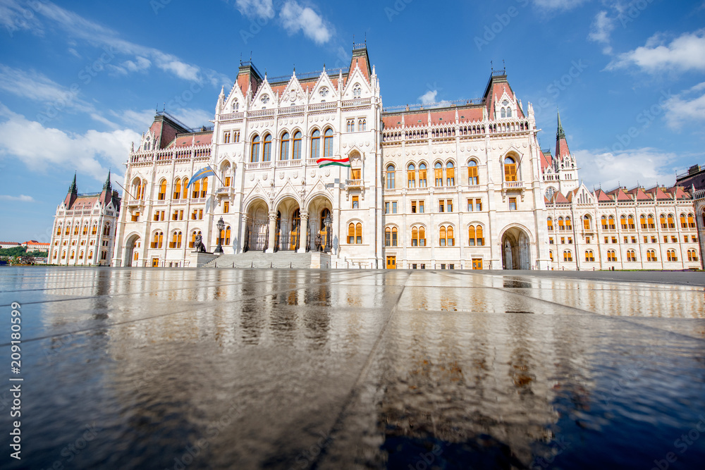 Fototapeta Widok na główną fasadę słynnego budynku Parlamentu z odbiciem w wodzie podczas porannego światła w Budapeszcie na Węgrzech
