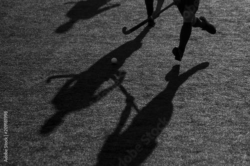 Silhouette. The shadow of a hockey player is running with a hockey stick on a hockey field. photo