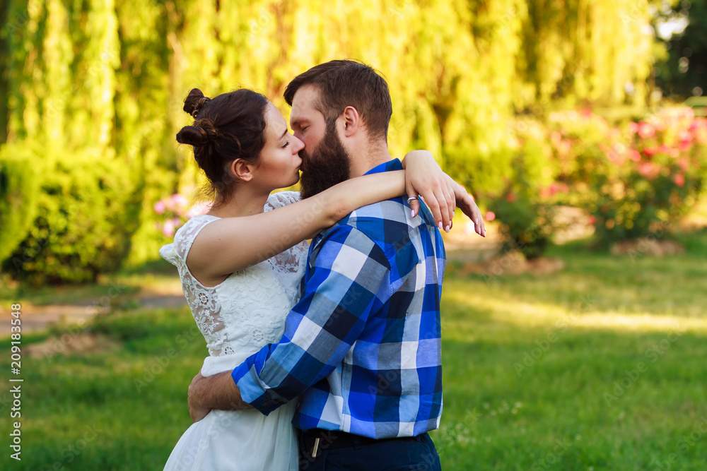 Beautiful guy and girl hugging and kissing. Love story photo on outdoor in sunset light. Couple in love. Pretty girl and brutal bearded guy in outdoor. Beautiful guy and girl hugging and kissing. Love story photo on outdoor in sunset light. Couple in love. Pretty girl and brutal bearded guy in outdoor.