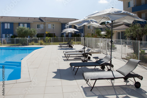 swimming pool in resort summer with chairs and umbrella