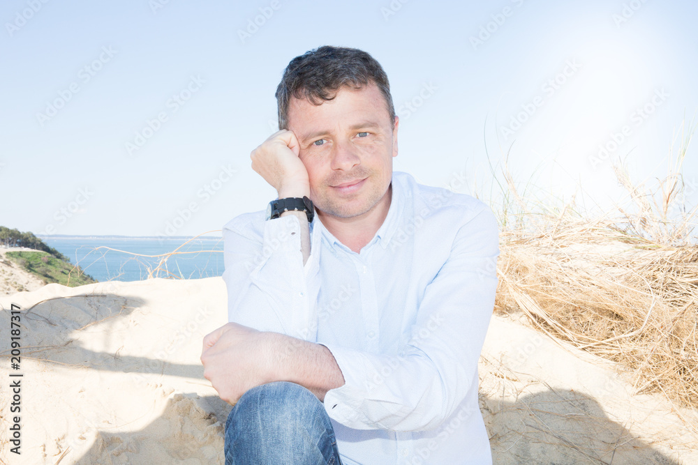 friendly handsome man relax on sand beach summer