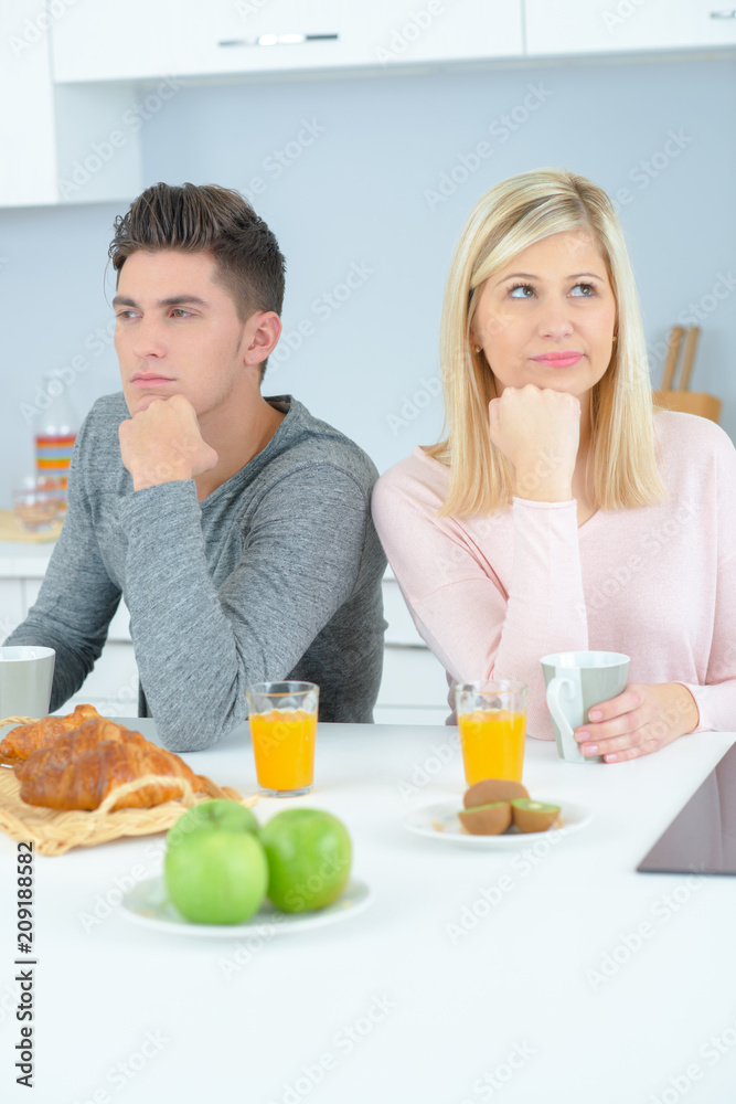 Couple at breakfast ignoring each other