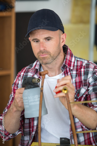 worker manufacturing a copper tube photo