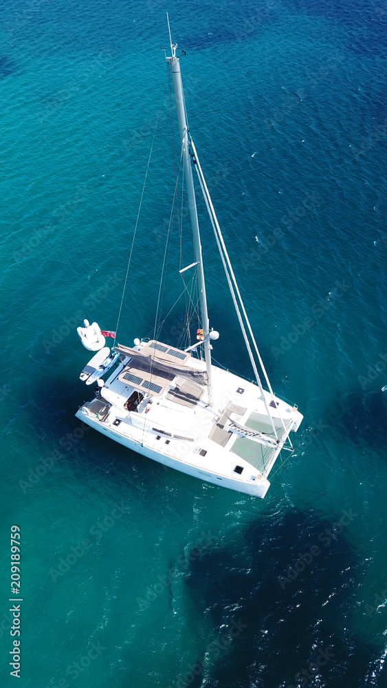 Aerial drone bird's eye view photo from luxury Catamaran docked at tropical deep waters 
