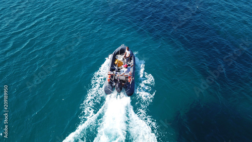 Aerial bird's eye view of inflatable rib boat cruising in high speed in turquoise clear water sea © aerial-drone