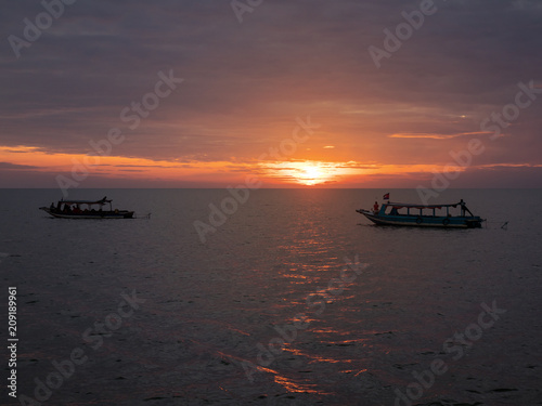 Boats on a beautiful lake in Cambodia at sunset
