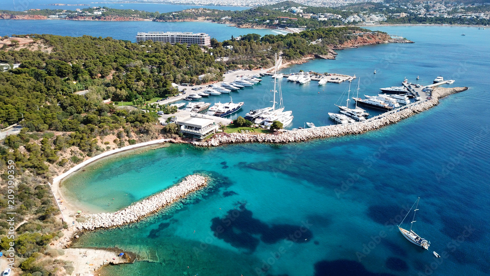 Aerial drone bird's eye photo of famous marina of Vouliagmeni with luxury yachts docked in south Athens riviera Peninsula with turquoise clear waters, Greece