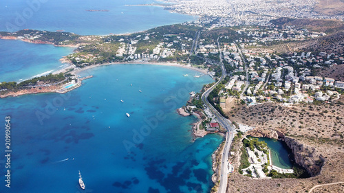 Aerial drone, bird's eye photo from iconic lake Vouliagmeni famous for healing abilities and Ateras Peninsula at the background, Athens riviera, Attica, Greece