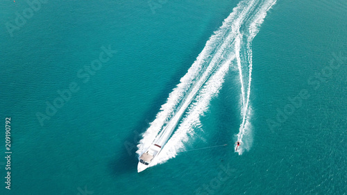 Aerial drone bird's eye view photo of man practicing water ski in tropical beach
