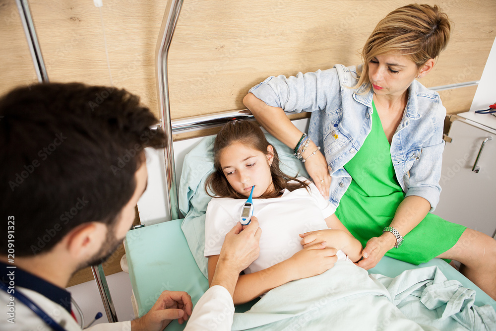 Doctor taking body temperature of her patient in hospital room Doctor taking body temperature of her patient in hospital room