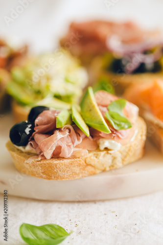 Tapas sandwich snack with ham on table. Closeup