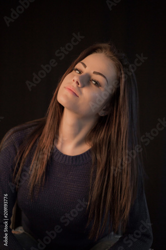 Studio portrait of young beautiful woman posing on black background