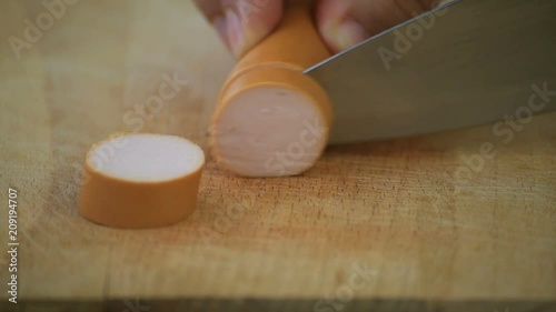 Cutting wieners on a wooden board photo