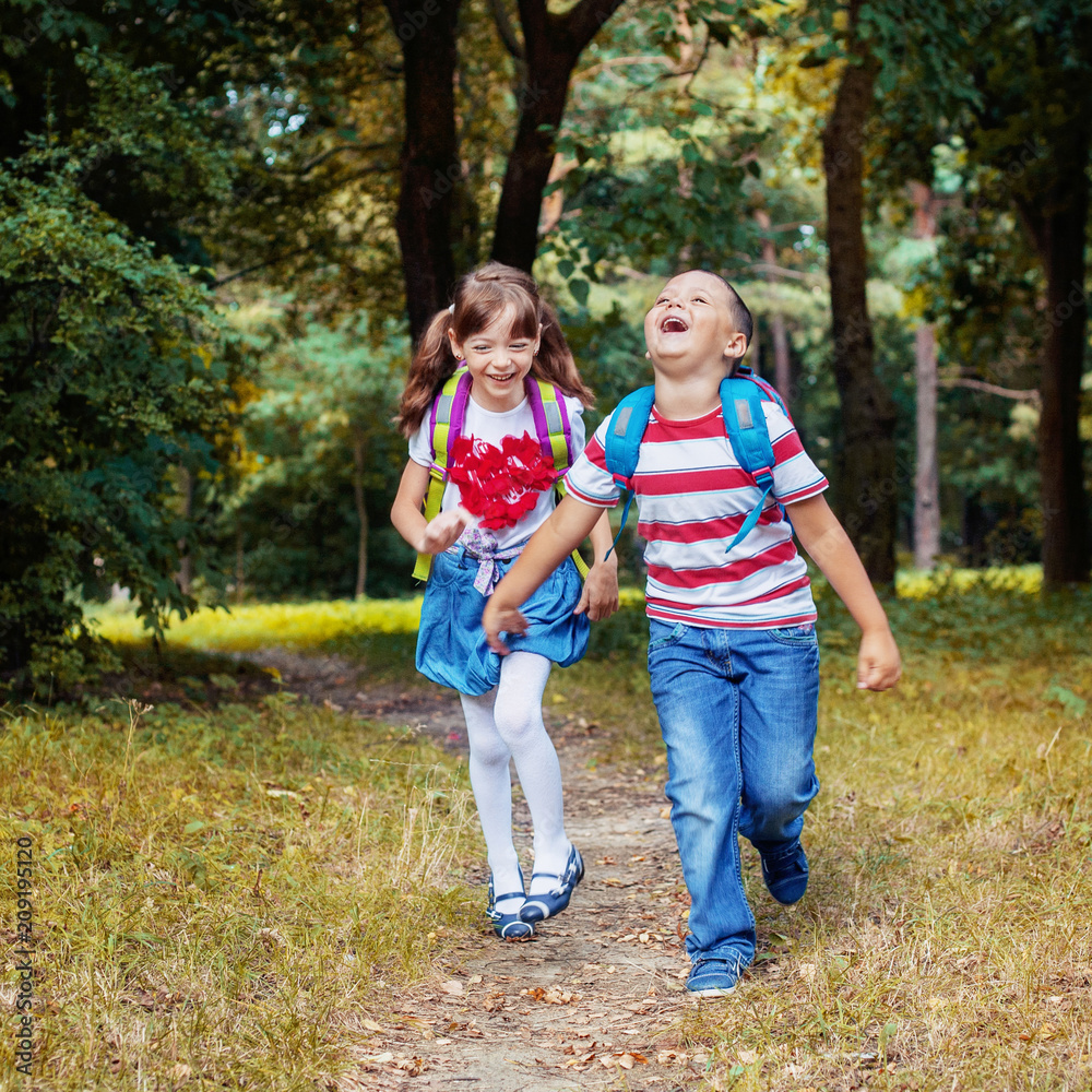 Happy children are running with backpacks from school. Square. The concept is back to school. Happy children are running with backpacks from school. Square. The concept is back to school.