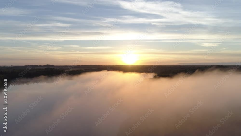 Aerial shot of a fog covered lake during sunrise in Latgale, Latvia Aerial shot of a fog covered lake during sunrise in Latgale, Latvia