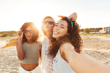 Three cheerful girls friends in summer clothes