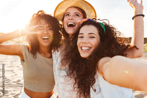 Three cheerful girls friends in summer clothes