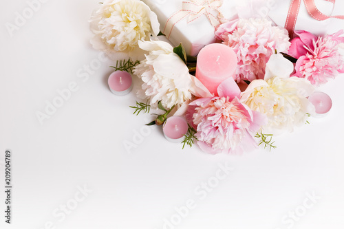 Festive flowers pink and white peony, gift, ribbon, candles composition on the white background. Overhead top view, flat lay. Copy space. Birthday, Mother's, Valentines, Women's, Wedding Day concept