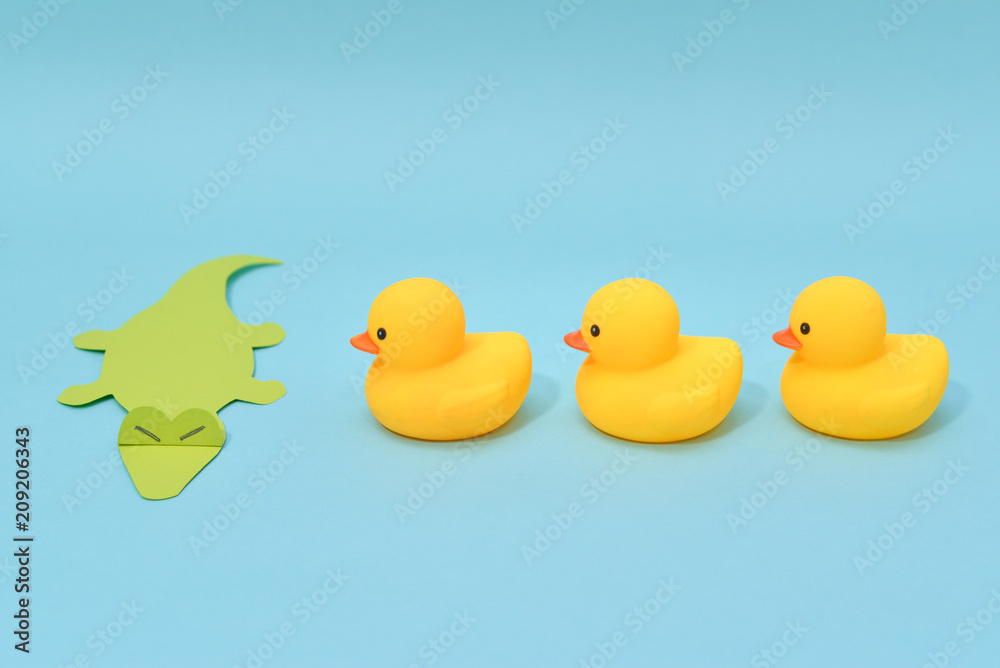 Challenge concept, rubber ducks are facing crocodile.