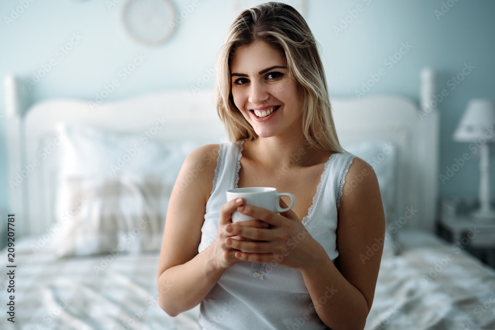Young beautiful woman sitting on bed at home