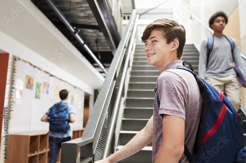 High School Students Walking Down Stairs In Busy College Building