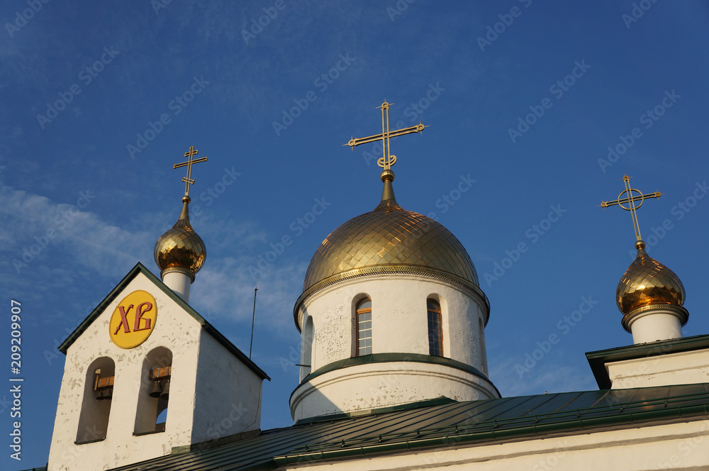 The orthodox church, Holy Trinity Cathedral in Kolpino, Russia. Gold domes with crosses and bells.