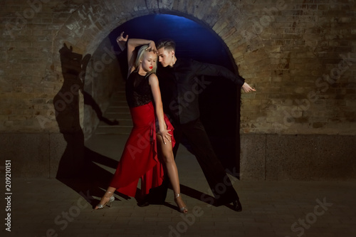 Two young and beautiful dancers perform the tango. Latin American dances.