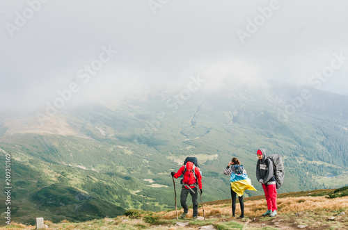 Fototapeta Naklejka Na Ścianę i Meble -  Hikers with backpacks in mountain and enjoying the view of valley