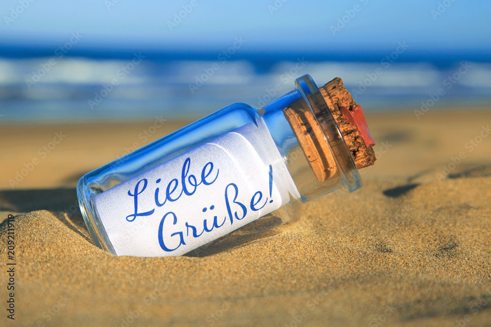 Flaschenpost am Strand Liebe Grüße! StockFoto Adobe Stock