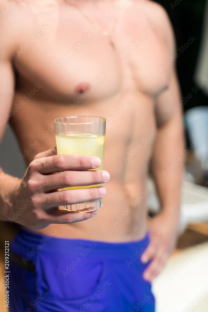 healthy lifestyle, party, vacation concept. close up of a cold fresh lemonade in the glass, young and strong man with rough body is holding it and posing healthy lifestyle, party, vacation concept. close up of a cold fresh lemonade in the glass, young and strong man with rough body is holding it and posing
