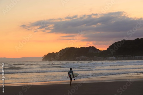 夕方の材木座海岸  夕陽をバックに海岸を歩くサーファーがカッコいい。 © masyok