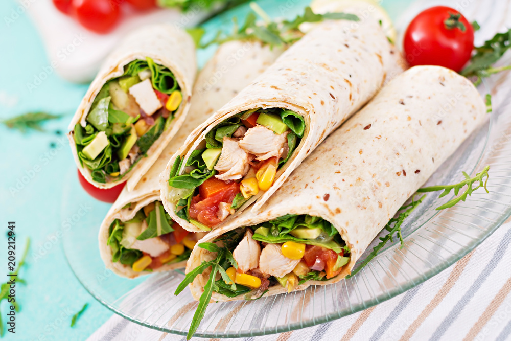Burritos wraps with chicken and vegetables on light  background. Chicken burrito, mexican food.