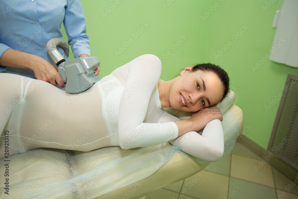 beautiful young girl on the procedure of anti-cellulite massage in the office of cosmetology