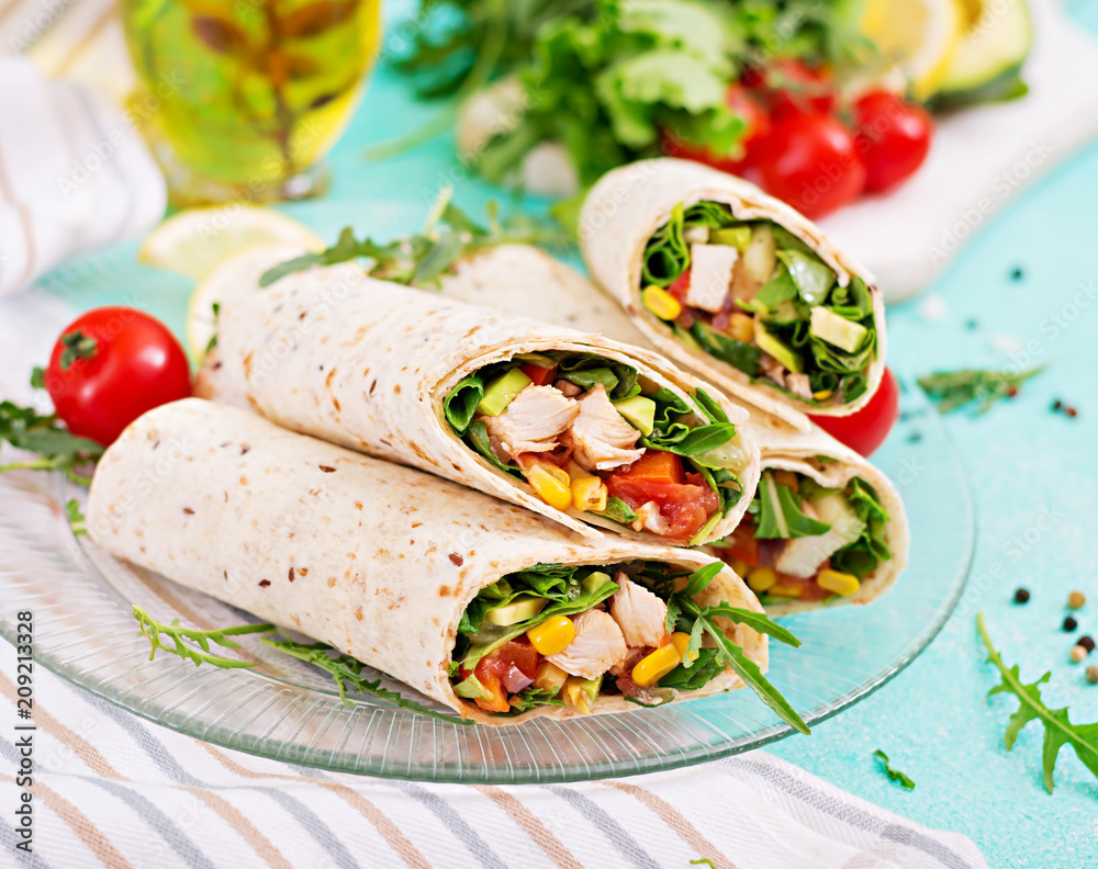 Burritos wraps with chicken and vegetables on light background. Chicken burrito, mexican food. Burritos wraps with chicken and vegetables on light background. Chicken burrito, mexican food.
