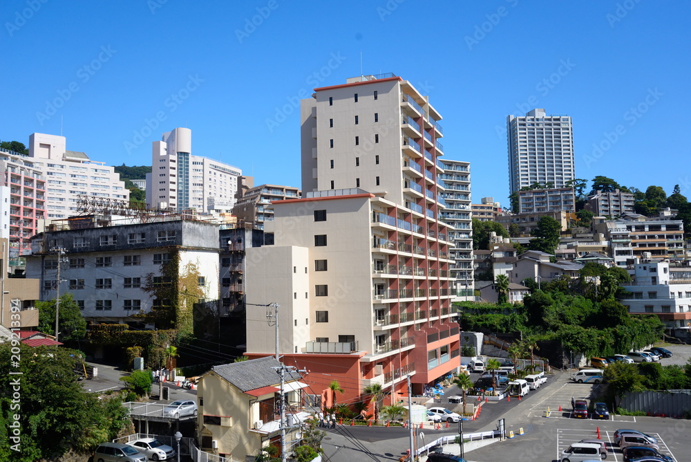 Fototapeta premium 熱海の海岸と丘陵に建つマンション 崖っぷちに立つ高層マンションが印象的だ