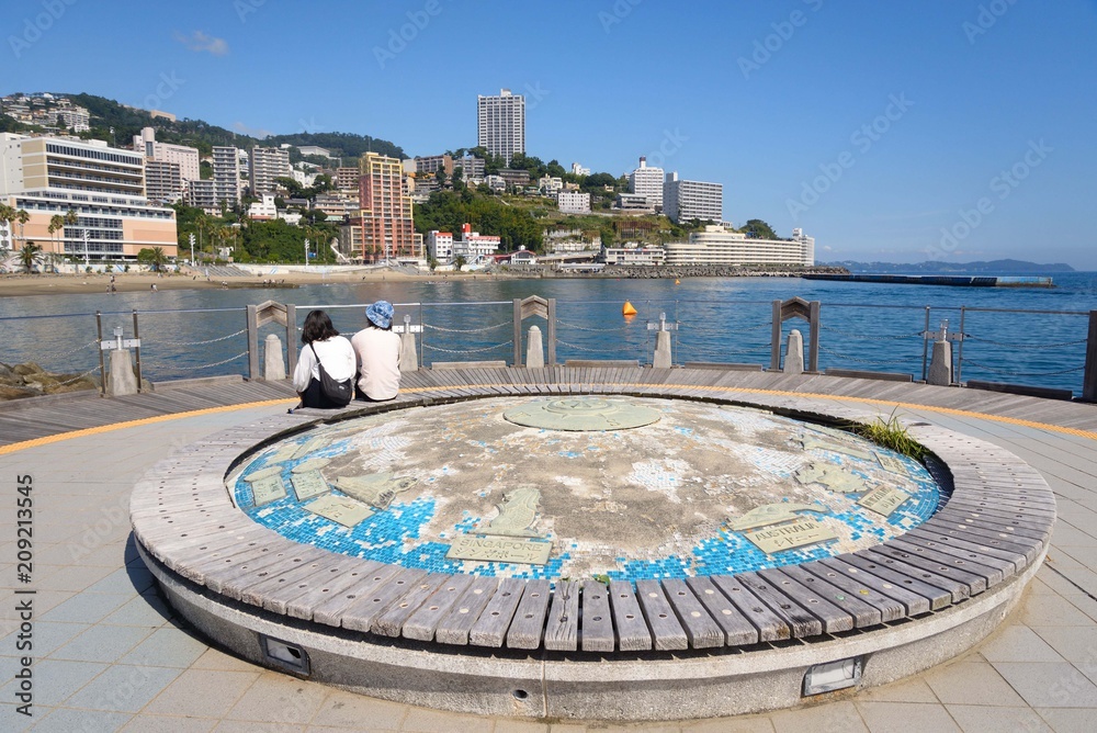 Naklejka premium 熱海の海岸と丘陵に建つマンションと地球儀 崖っぷちに立つ高層マンションが印象的だ