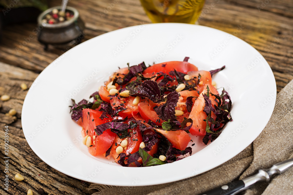 Salad from tomatoes with a violet basil and pine nuts. Vegan food. Italian meal. Salad from tomatoes with a violet basil and pine nuts. Vegan food. Italian meal.