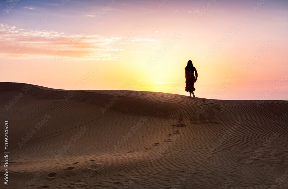 Woman in the desert with sunset view