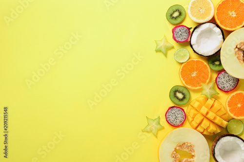 Fototapeta Naklejka Na Ścianę i Meble -  Exotic fruits on pastel yellow background - papaya, mango, pineapple, banana, carambola, dragon fruit, kiwi, lemon, orange, melon, coconut, lime. Top view.