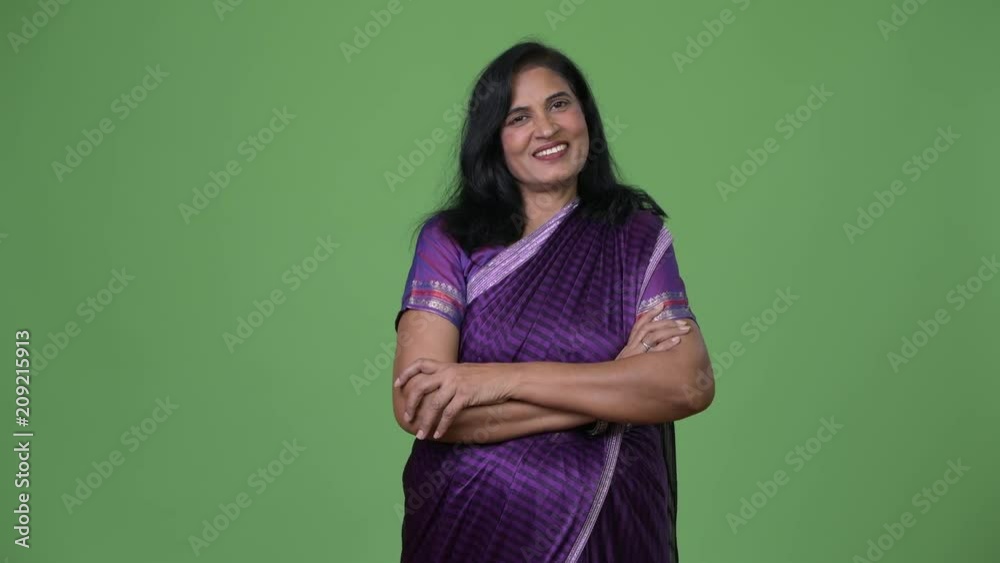 Mature happy beautiful Indian woman with arms crossed wearing Sari traditional clothes