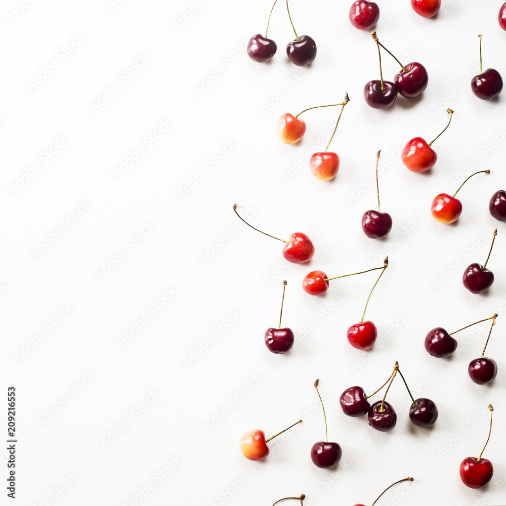 Yellow and dark red berries of a sweet cherry on a white background. Summer concept. Top view, flat lay, copyspace